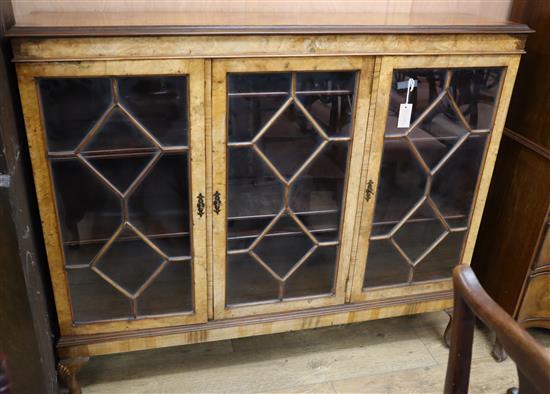 A figured walnut bookcase fitted three astragal-glazed doors W.138cm